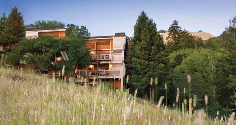 A view of the lodgings from across a grass meadow